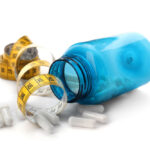 Blue bottle on its side with pills spilling out and a cloth tape measure to represent best prescription weight loss pillseight loss pills